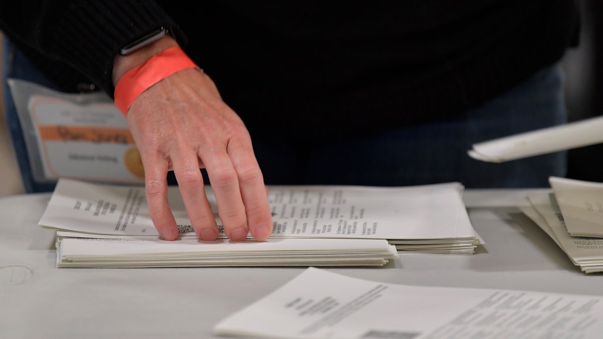 Cobb County Election officials handle ballots during an audit, Monday, Nov. 16, 2020, in Marietta, Ga. (AP Photo/Mike Stewart)
