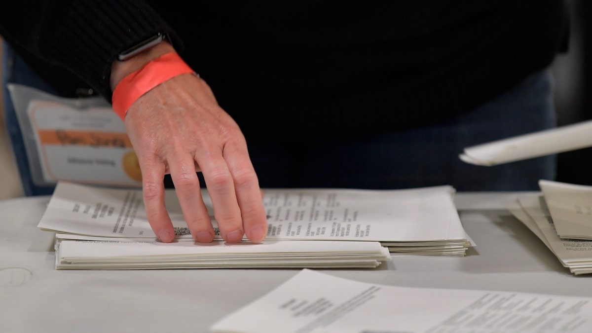 Cobb County Election officials handle ballots during an audit, Monday, Nov. 16, 2020, in Marietta, Ga. (AP Photo/Mike Stewart)