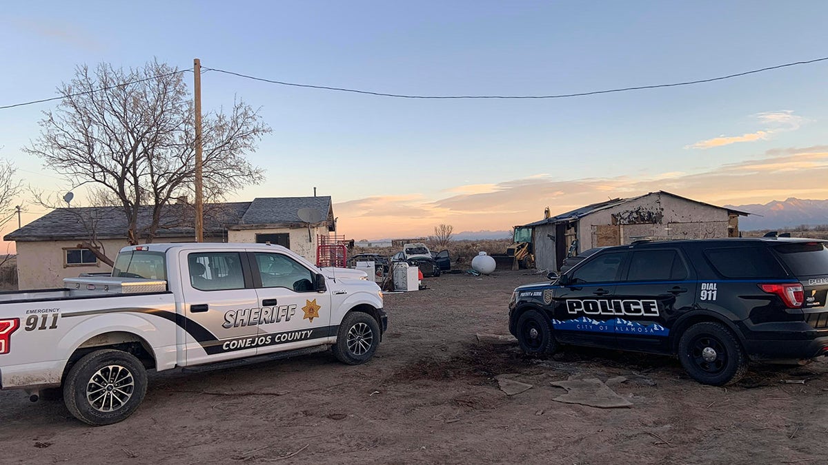 In this photo released by the Colorado Bureau of Investigation, law enforcement vehicles are parked at one of two properties where skeletal remains were found about 20 miles south-southeast of Alamosa, Colo., on Wednesday, Nov. 18, 2020. (Colorado Bureau of Investigation via AP)