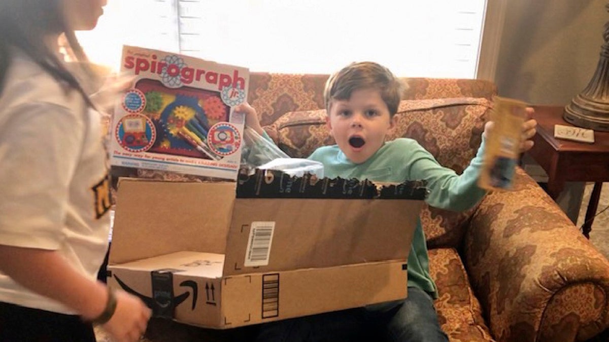 Chip Matthews, 6, opens a birthday present at his home in Opelika, Ala., on Thursday, Nov. 5, 2020. Matthews was given an extra birthday surprise when postal worker, Tawanna Purter, gave him $2 as a gift. (Bonnie Matthews via AP)