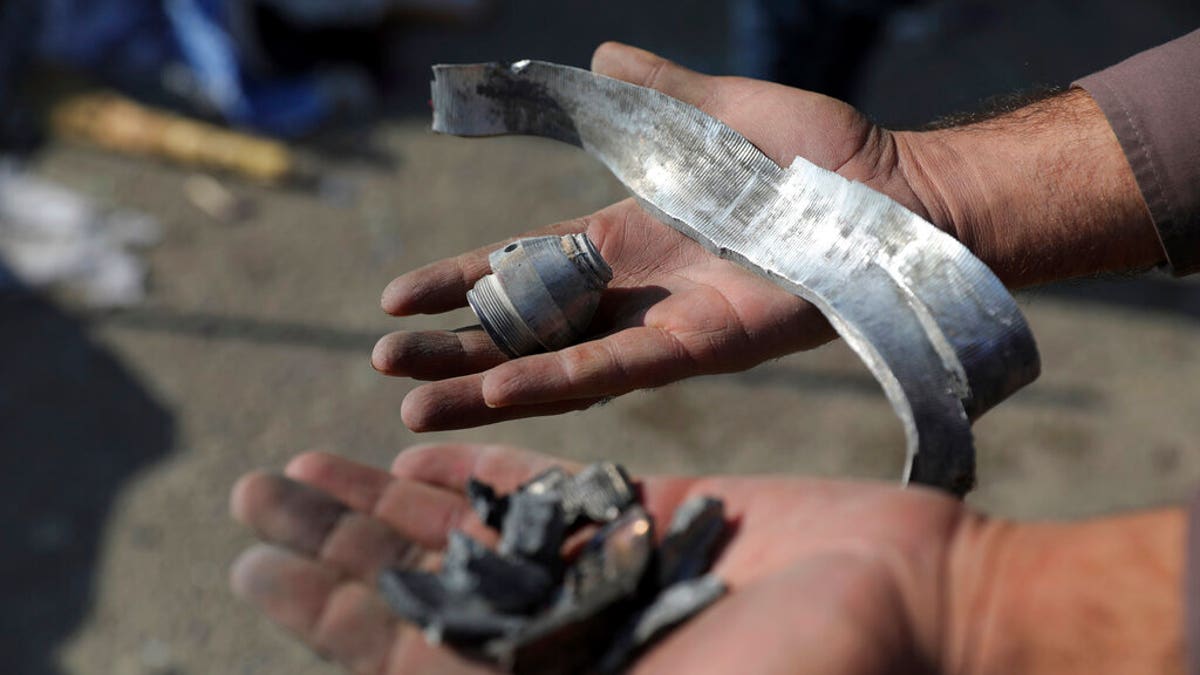 An Afghan man holds rocket shell after a rocket attack in Kabul, Afghanistan, Saturday, Nov. 21, 2020. Mortar shells slammed into different parts of the Afghan capital on Saturday, killing several and wounding dozens of people, an official said. (AP Photo/Rahmat Gul)