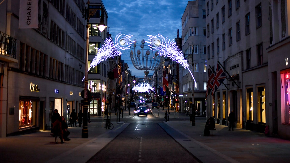 Christmas lights are lit up on New Bond Street in Mayfair, London, Tuesday, Nov. 24, 2020. Haircuts, shopping trips and visits to the pub will be back on the agenda for millions of people when a four-week lockdown in England comes to an end next week, British Prime Minister Boris Johnson said Monday. (AP Photo/Alberto Pezzali)