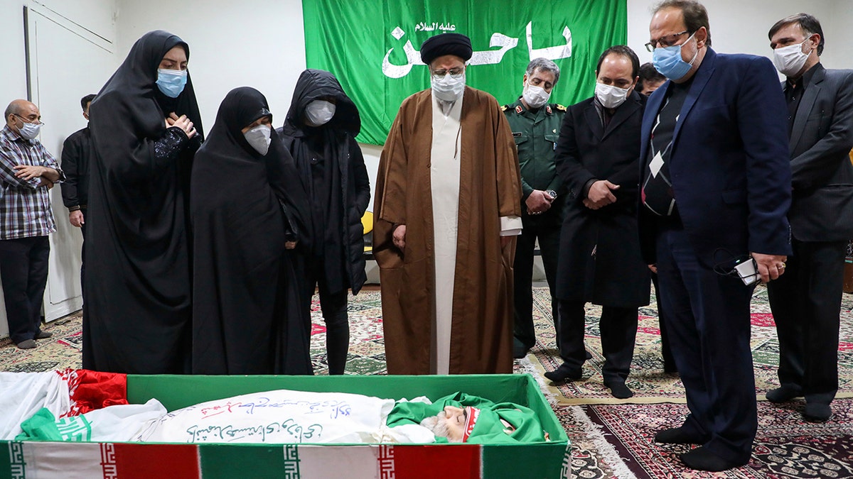 Iran's Judiciary Chief Ayatollah Ebrahim Raisi pays his respect to the body of slain scientist Mohsen Fakhrizadeh among his family, in Tehran, Iran, Saturday, Nov. 28, 2020. Iranian officials have blamed Israel for the killing of Fakhrizadeh who led Tehran's disbanded military nuclear program. (Mizan News Agency via AP)