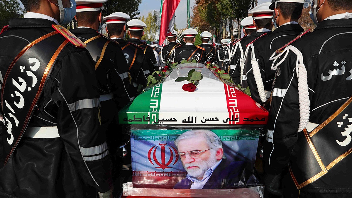 In this photo released by the official website of the Iranian Defense Ministry, military personnel stand near the flag-draped coffin of Mohsen Fakhrizadeh, a scientist who was killed on Friday, during a funeral ceremony in Tehran, Iran, Monday, Nov. 30, 2020. (Iranian Defense Ministry via AP)
