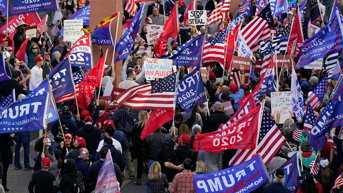 Supporters of President Donald Trump protest in front of a local hotel where Arizona Republicans have scheduled a meeting as a "fact-finding hearing" to discuss the election, featuring members of Trump's legal team and Arizona legislators, Monday, Nov. 30, 2020, in Phoenix. (AP Photo/Ross D. Franklin)