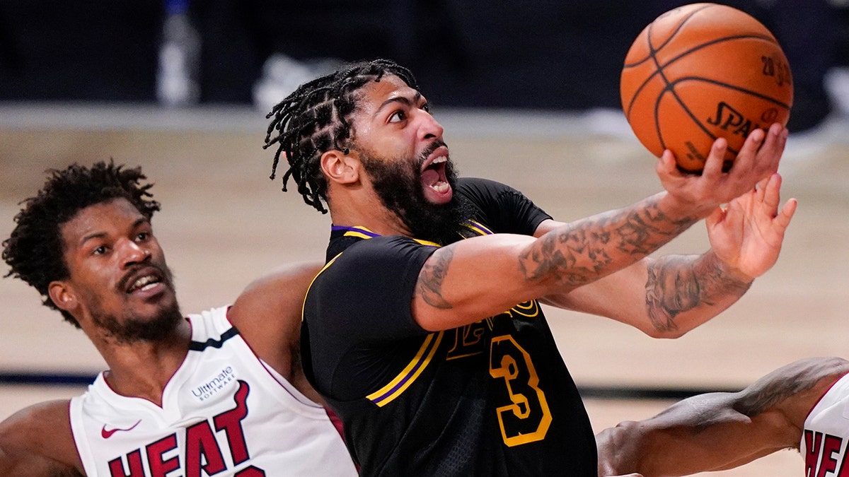 In this Oct. 9, 2020, file photo, Los Angeles Lakers forward Anthony Davis shoots past Miami Heat forward Jimmy Butler during the second half in Game 5 of the NBA Finals in Lake Buena Vista, Fla. AP Photo/Mark J. Terrill, File)