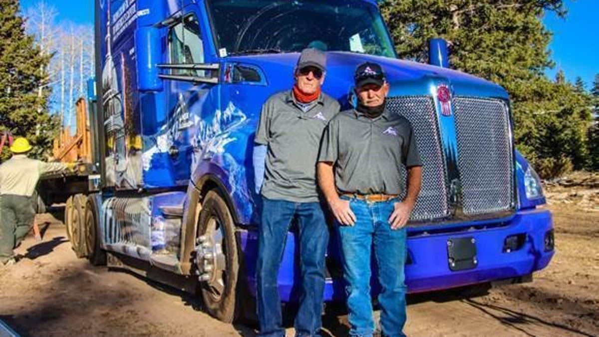 Theron Schmalzried, left, and Butch Hanna, right, the two professional truck drivers transporting the U.S. Capitol Christmas tree, pictured at the tree cutting ceremony in the Grand Mesa, Uncompahgre and Gunnison (GMUG) National Forests on November 5. Photo credit: James Edward Mills