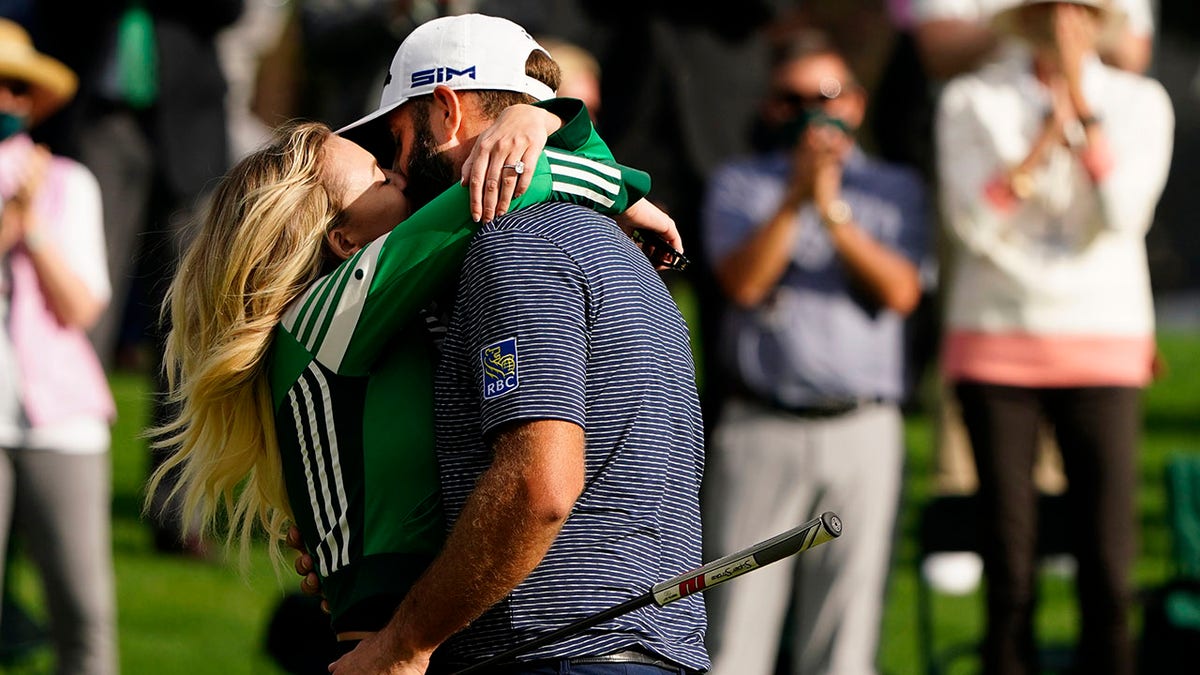 Dustin Johnson is hugged by his wife Pauline Gretzky after winning the Masters golf tournament Sunday, Nov. 15, 2020, in Augusta, Ga. (AP Photo/Matt Slocum)