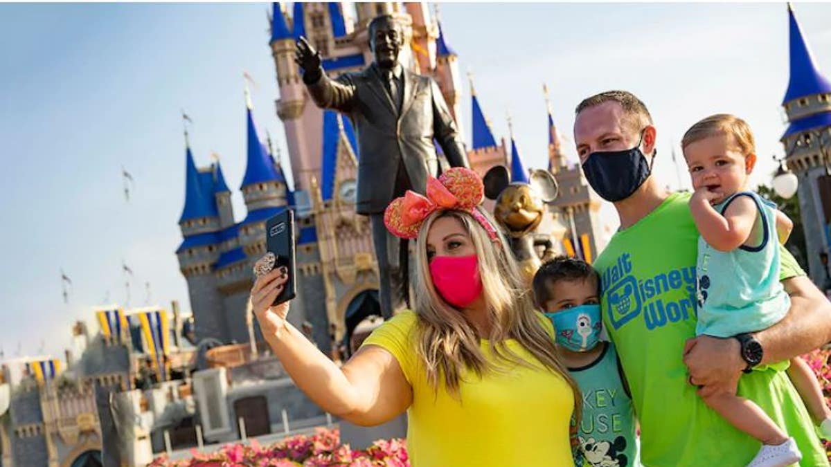 Guests stop to take a selfie at Magic Kingdom Park at Walt Disney World Resort on July 11, 2020 in Lake Buena Vista, Florida. (Photo by Matt Stroshane/Walt Disney World Resort via Getty Images)