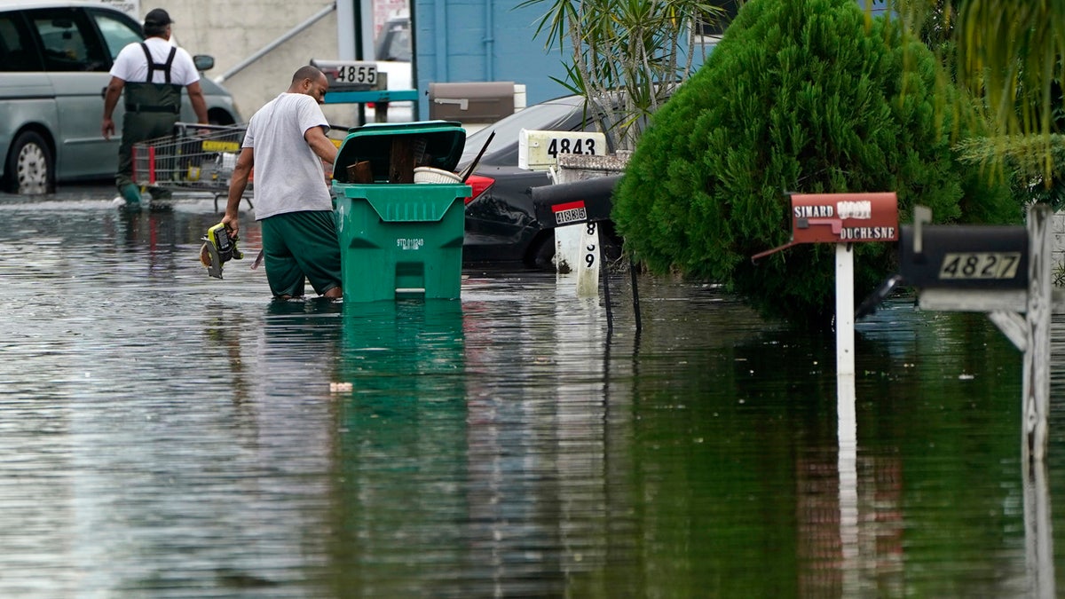 Residents clear debris from a flooded street in the Driftwood Acres Mobile Home Park, in the aftermath of Tropical Storm Eta, Nov. 10, in Davie, Fla. AP Photo/Lynne Sladky