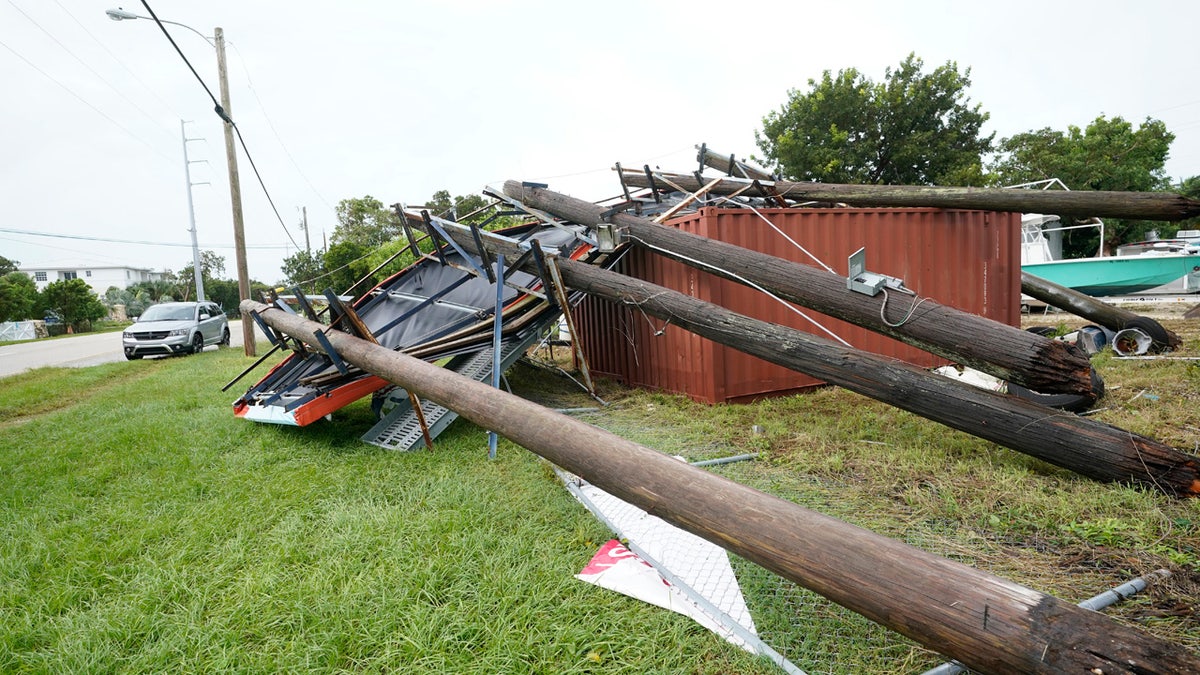 An advertising billboard lies on the ground after falling from high winds and rain from Tropical Storm Eta, Monday, Nov. 9, 2020, in Key Largo, Fla. The storm had top sustained winds of 65 mph Sunday night as it crossed over the Florida Keys.