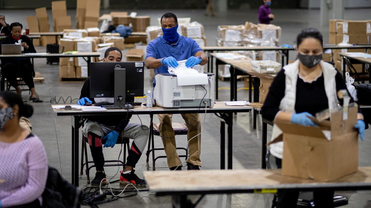 Workers scan ballots as the Fulton County presidential recount gets under way Wednesday morning, Nov. 25, 2020 at the Georgia World Congress Center in Atlanta. (AP Photo/Ben Gray)