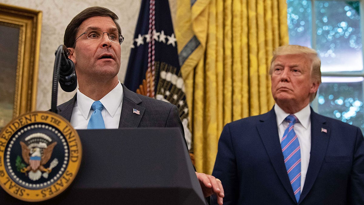 Mark Esper speaks as Donald Trump looks on