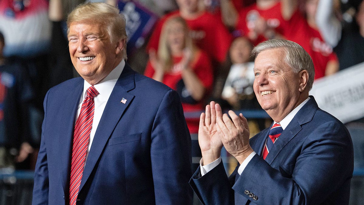 US president Donald Trump (L) smiles as he stands alongside US Senator Lindsey Graham (R), Republican of South Carolina. (Photo by SAUL LOEB / AFP) 