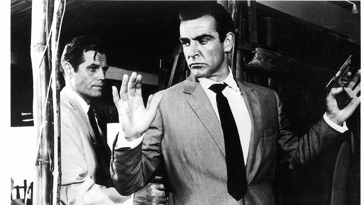 Sean Connery held at gunpoint by Jack Lord in a scene from the film 'James Bond: Dr. No', 1962.