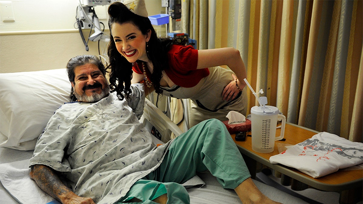 Tito Suazo, who served in the Air Force, gets a hug from Gina Elise, Founder of the non-profit organization, Pin-Ups For Vets, during her visit to the Denver VA Medical Center Wednesday, December 14, 2011. 