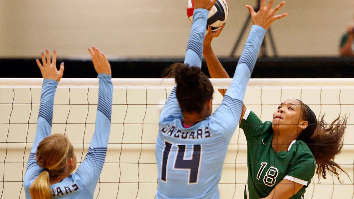 Reagan’s Kyla Waiters, right, spikes the ball past Johnson from the Texas District 26-6A high school volleyball match Friday, Sept. 22, 2017. Waiters, who went on to sign a scholarship at Oregon State, was among a half-dozen players who reached out to The Associated Press after a July 2020 story in which players, parents and people familiar with the program said Oregon State coaches physically and emotionally abused some players while the administration took no outward steps to address complaints. (Ron Cortes/The San Antonio Express-News via AP)
