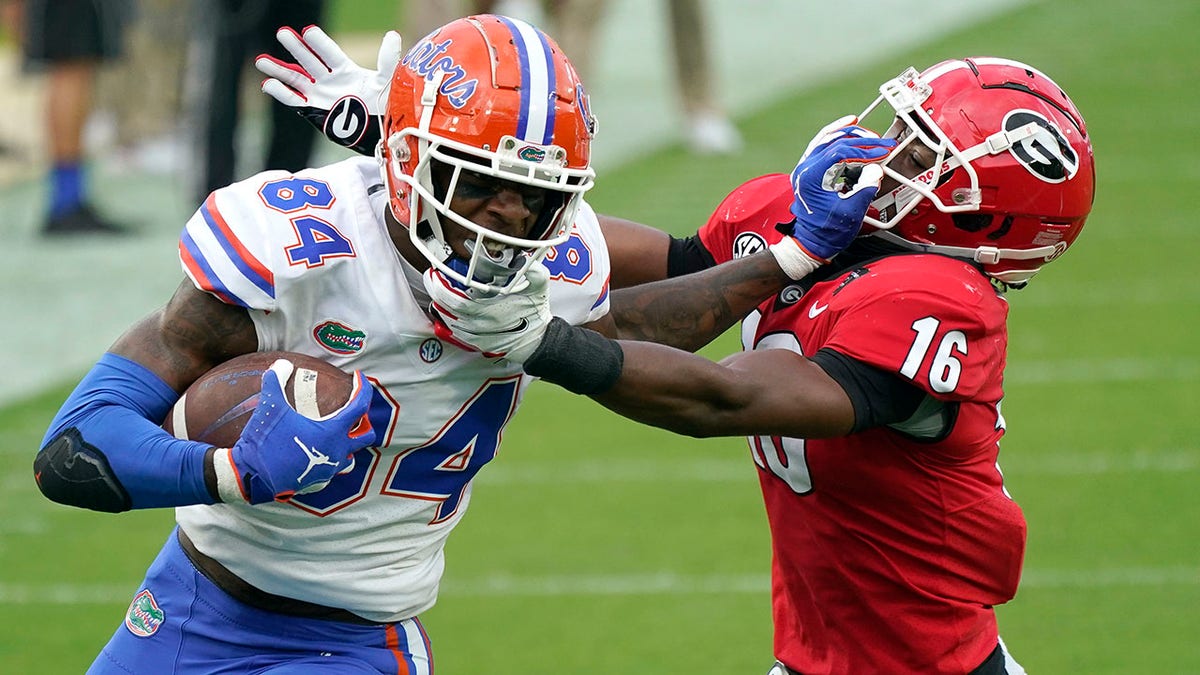 Florida tight end Kyle Pitts (84) tires to get past Georgia defensive back Lewis Cine (16) after a reception during the first half of an NCAA college football game, Saturday, Nov. 7, 2020, in Jacksonville, Fla. (AP Photo/John Raoux)