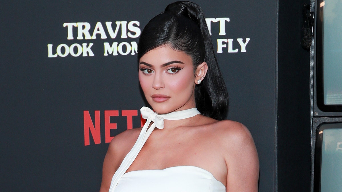 Kylie Jenner posted a pair of seductive photos on Monday from her living room in a skin-tight, strapless dress.