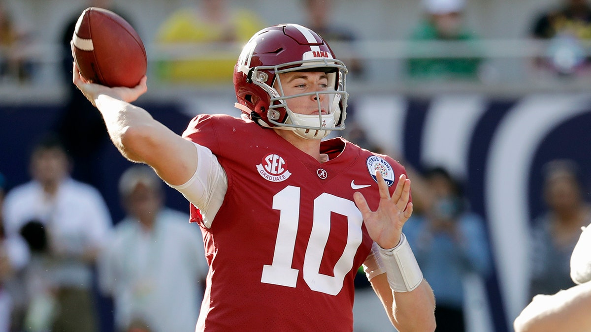 FILE- In this Jan. 1, 2020, file photo, Alabama quarterback Mac Jones (10) throws a pass during the second half of the Citrus Bowl NCAA college football game against Michigan in Orlando, Fla. Alabama quarterback Mac Jones and Auburn's Bo Nix have taken different paths to their starting jobs. Now, they'll lead their teams into the Iron Bowl for the second straight year. (AP Photo/John Raoux, File)