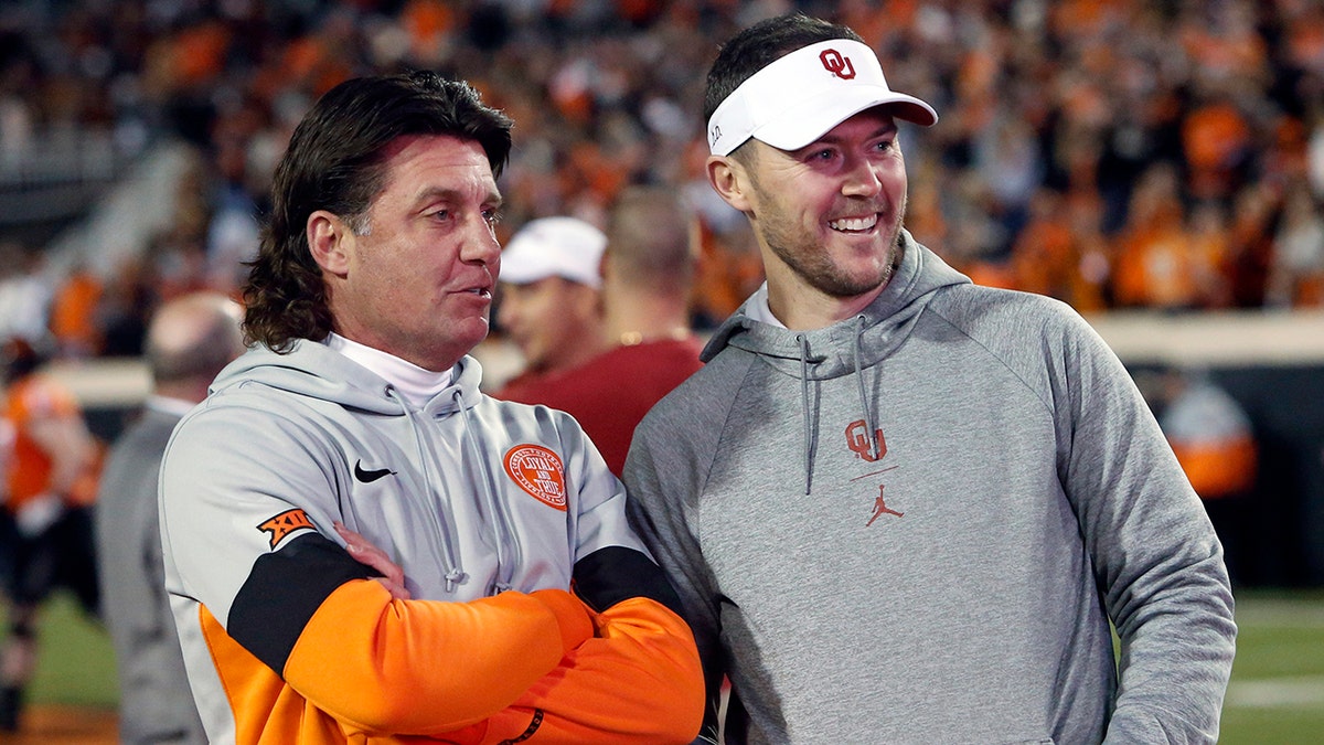 FILE - In this Nov. 30, 2019, file photo, Oklahoma State coach Mike Gundy, left, talks with Oklahoma coach Lincoln Riley before an NCAA college football game in Stillwater, Okla. The teams meet this week in the Bedlam game.