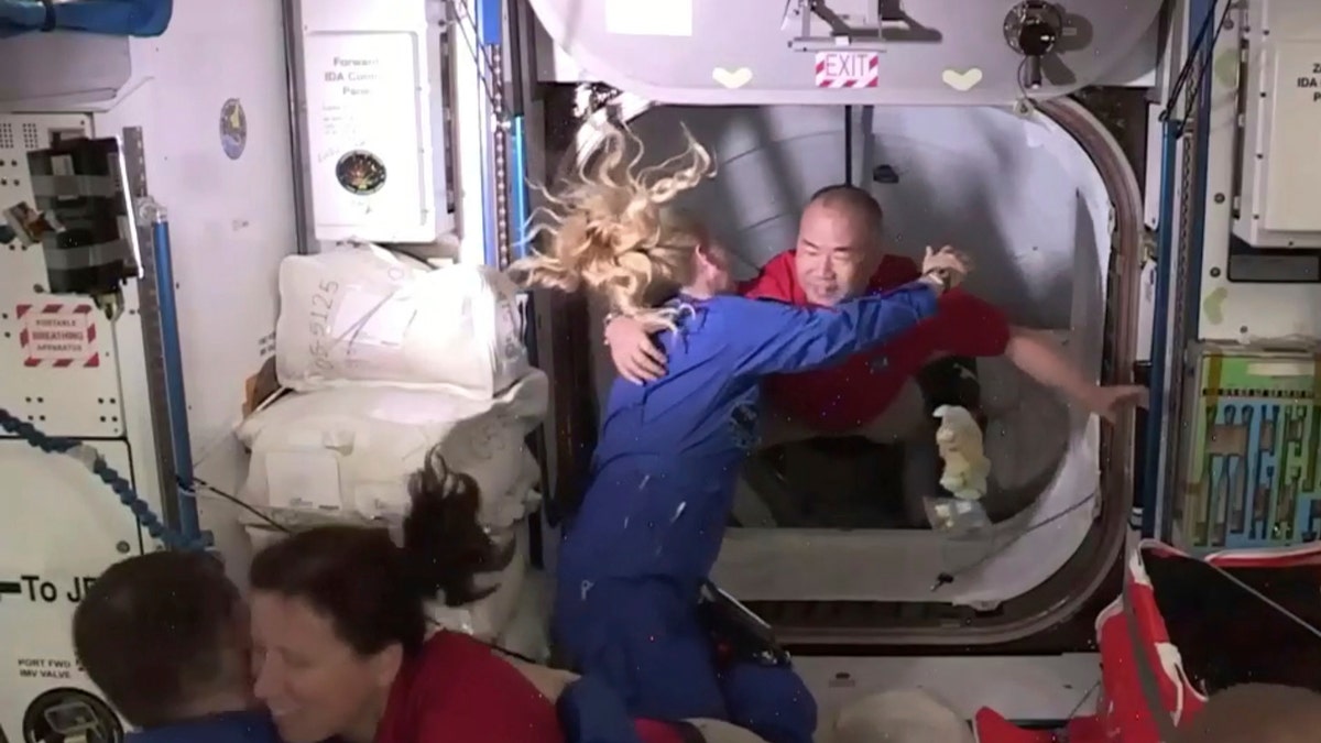 In this frame grab from NASA TV, astronaut Soichi Noguchi, background right, is greeted by astronaut Kate Rubins, as he enters the International Space Station from the vestibule between the SpaceX Dragon capsule and the ISS, early Tuesday, Nov. 17, 2020.