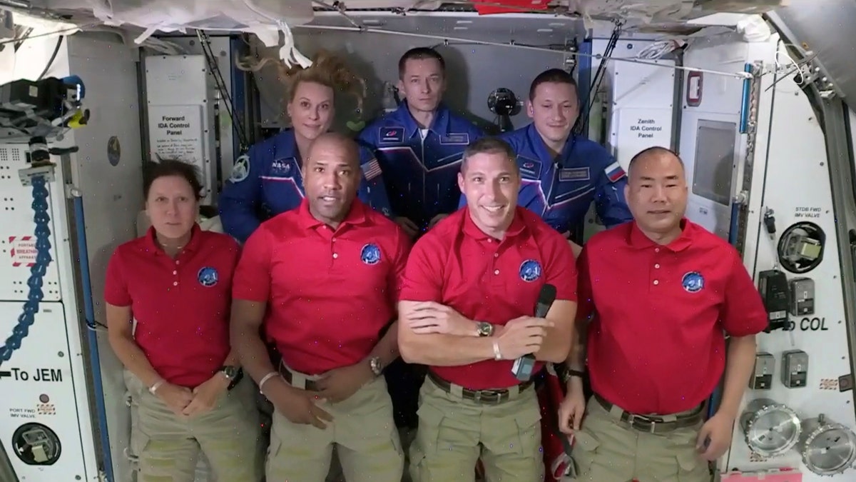 In this frame grab from NASA TV, SpaceX Dragon crew, from front left to right, Shannon Walker, Victor Glover, Mike Hopkins and Soichi Noguchi stand with International Space Station crew Kate Rubins, from back left, Expedition 64 commander Sergey Ryzhikov and Sergey Kud-Sverchkov during a welcome ceremony, early Tuesday, Nov. 17, 2020. The Dragon arrived and docked at the ISS late Monday. (NASA TV via AP)