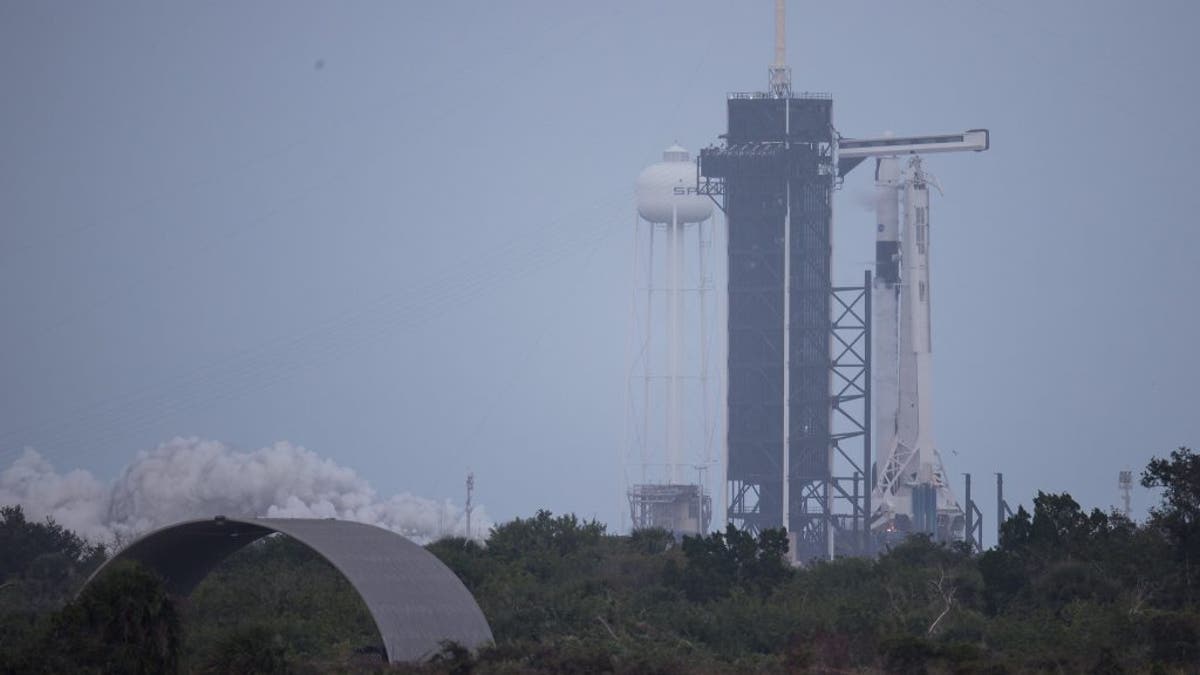 A SpaceX Falcon 9 rocket with the firm's Crew Dragon spacecraft onboard on the launch pad at Launch Complex 39A at Kennedy Space Center in Florida. The rocket was photographed during a short static fire test ahead of the Crew-1 mission.
