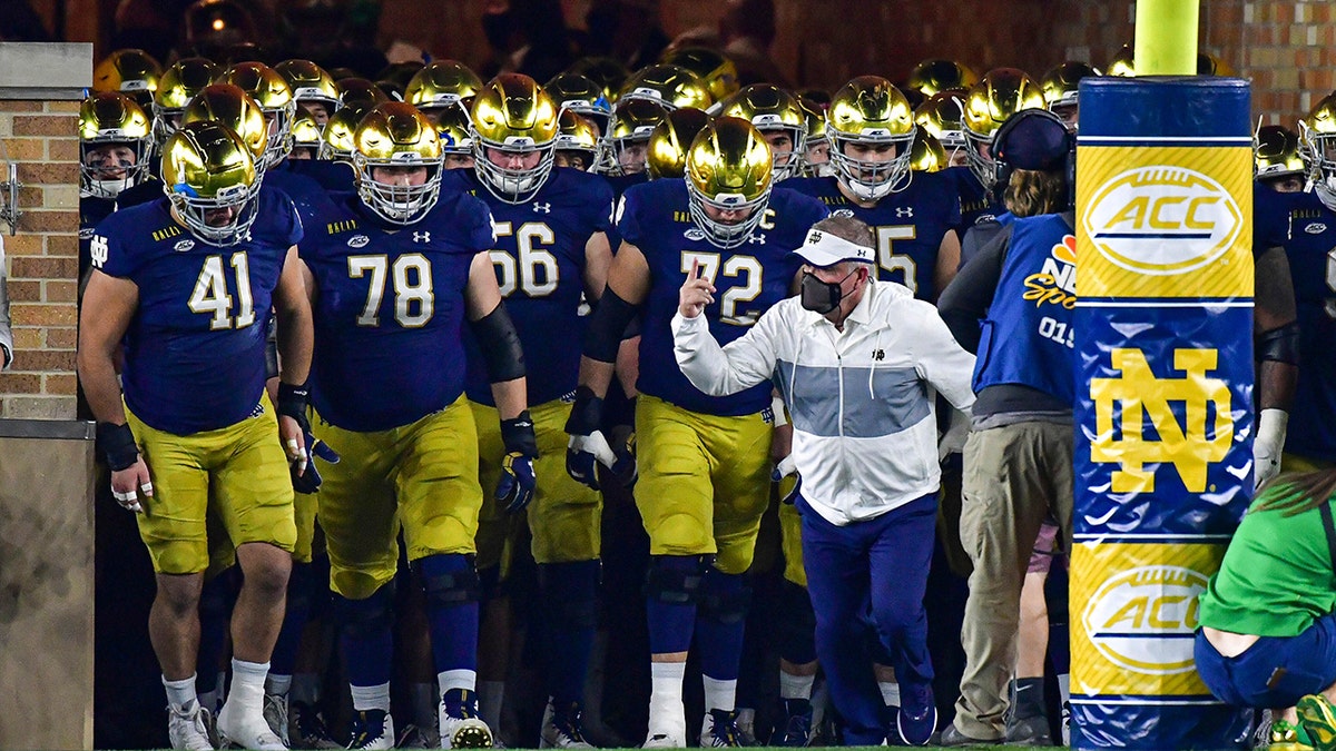 Notre Dame coach Brian Kelly leads the team out of the tunnel for an NCAA college football game against Clemson on Saturday, Nov. 7, 2020, in South Bend, Ind. (Matt Cashore/Pool Photo via AP)