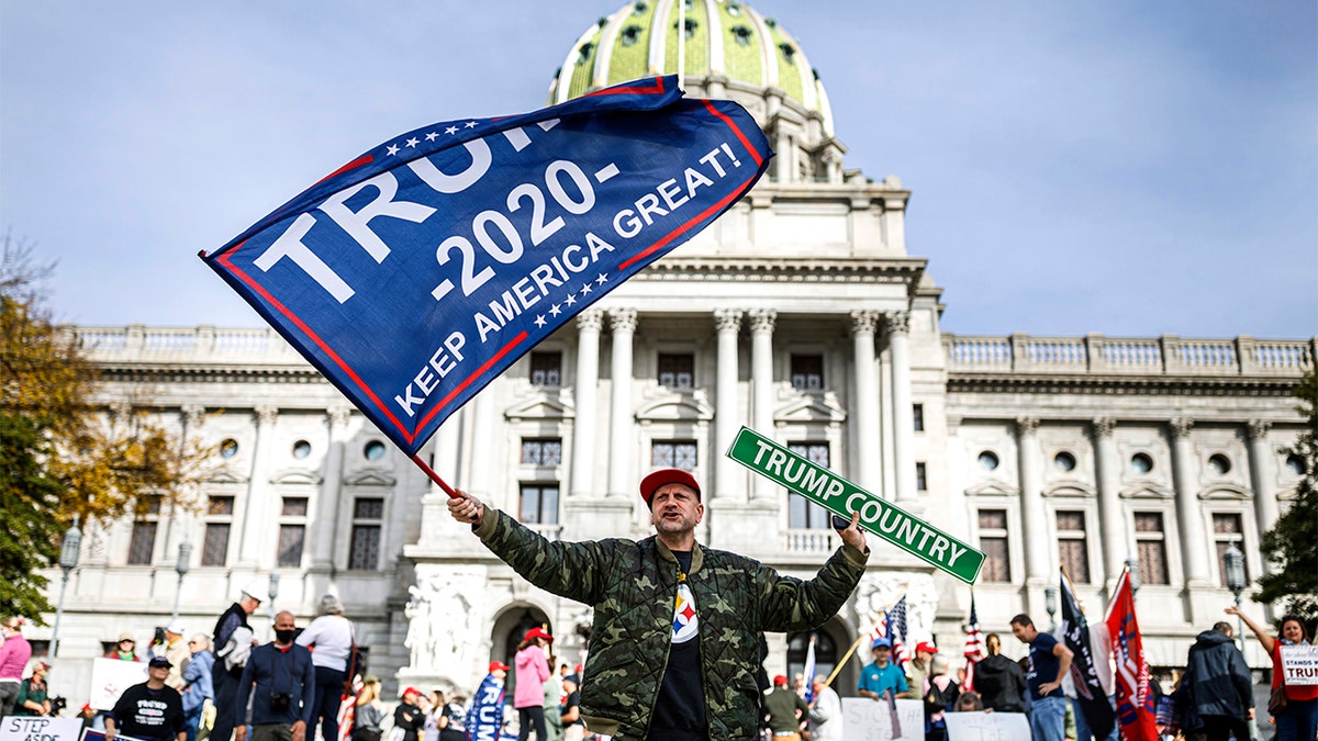 A man waves a flag at a pro-Trump rally at the Pennsylvania state Capitol in Harrisburg, Pa., Nov. 5. (Dan Gleiter/The Patriot-News via AP)