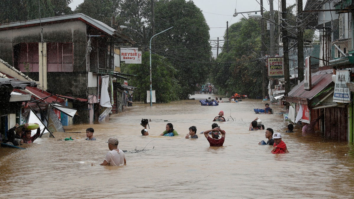 Residents negotiate a flooded road as floods continue to rise in Marikina, Philippines, due to Typhoon Vamco on Thursday, Nov. 12, 2020.