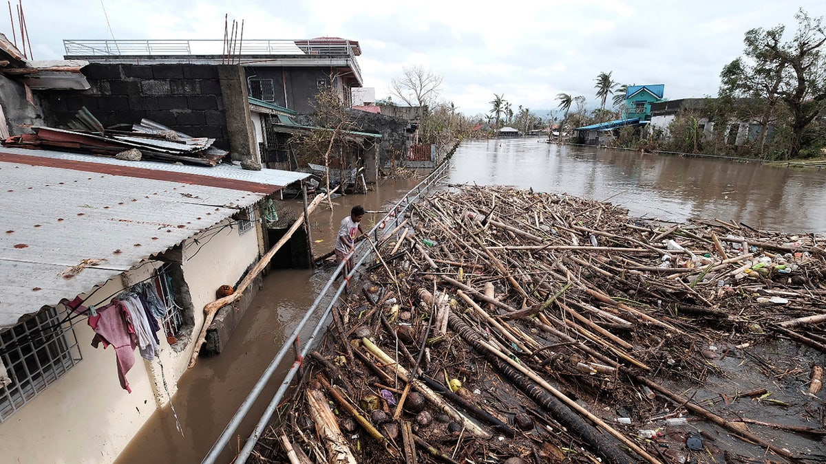 A man looks at the garbage that was washed away due to Typhoon Vamco as floods inundate villages in Legazpi, Philippines, on Thursday, Nov. 12, 2020.