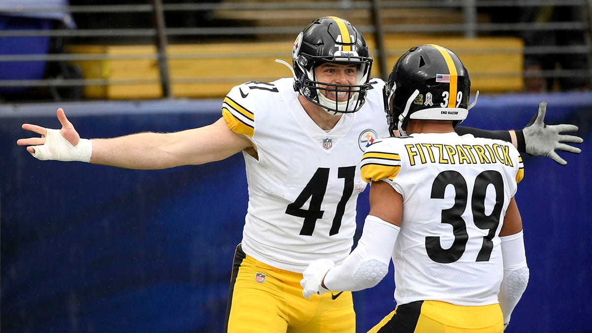 Pittsburgh Steelers linebacker Robert Spillane, left, celebrates with free safety Minkah Fitzpatrick after scoring on an interception of a pass from Baltimore Ravens quarterback Lamar Jackson, not visible, during the first half of an NFL football game, Sunday, Nov. 1, 2020, in Baltimore. (AP Photo/Nick Wass)