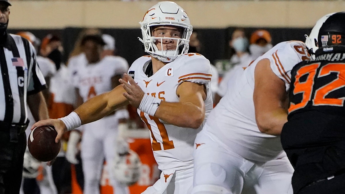 Texas quarterback Sam Ehlinger (11) throws a touchdown pass in overtime of an NCAA college football game against Oklahoma State in Stillwater, Okla., Saturday, Oct. 31, 2020. (AP Photo/Sue Ogrocki)