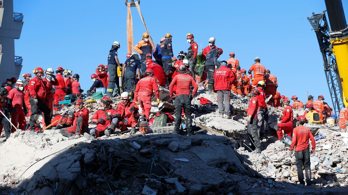 Members of rescue services search in the debris of a collapsed building for survivors in Izmir, Turkey, early Sunday, Nov. 1, 2020.