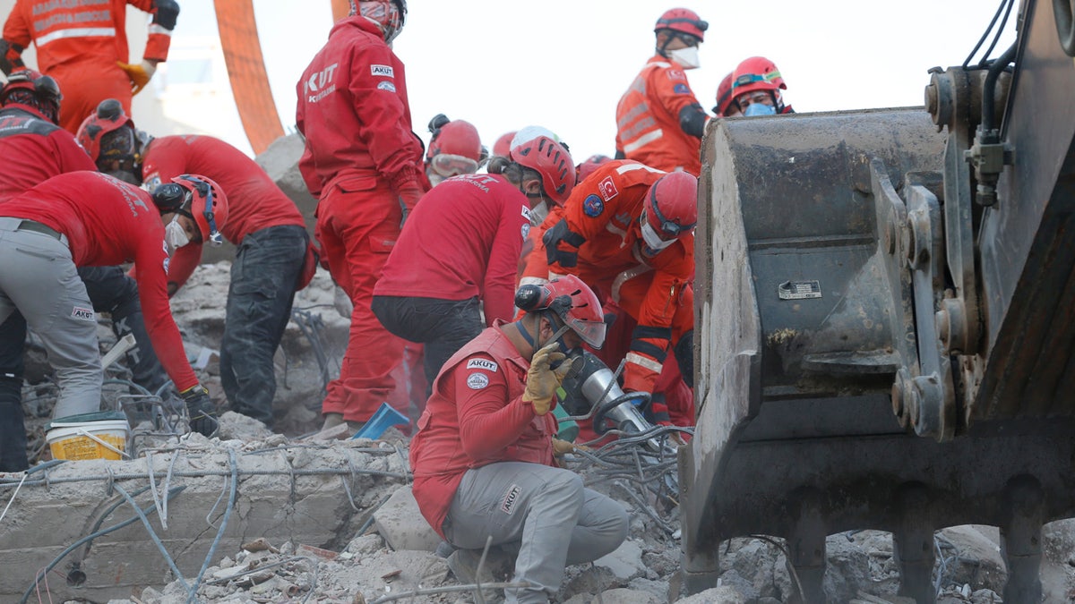 Members of rescue services search in the debris of a collapsed building for survivors in Izmir, Turkey, Sunday, Nov. 1, 2020.