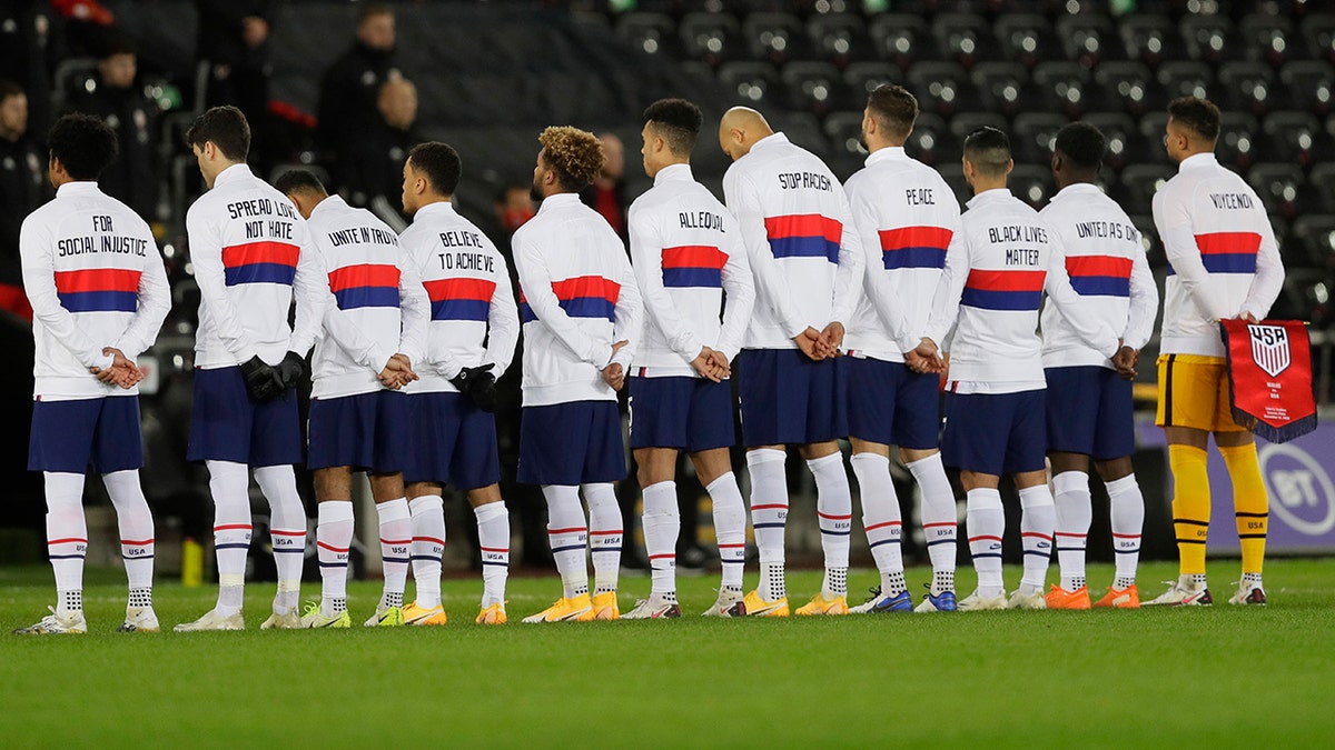 US team members stand for their national anthem before the international friendly soccer match between Wales and USA at Liberty Stadium in Swansea, Wales, Thursday, Nov. 12, 2020. (AP Photo/Kirsty Wigglesworth)