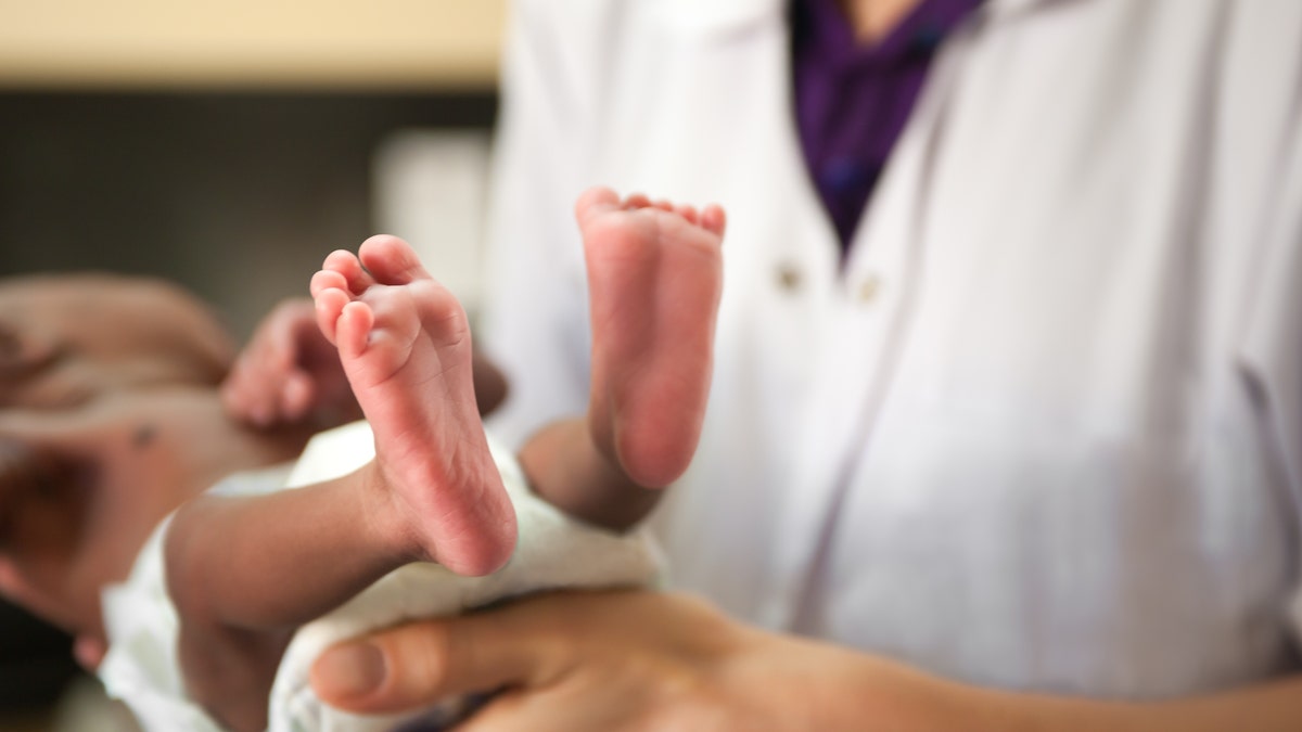 Doctor holds baby's feet