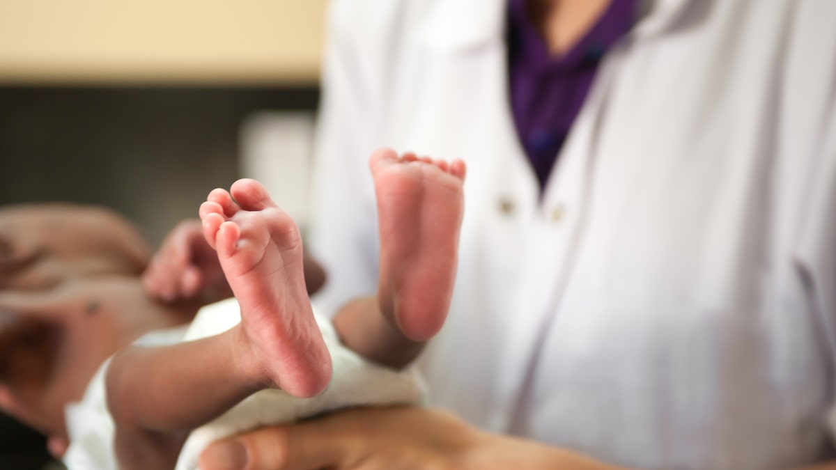 Doctor holds baby's feet