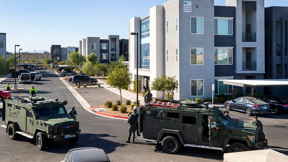 Henderson Police officers and SWAT vehicles are shown at the scene of a fatal shooting in an apartment complex in Henderson, Nevada.  Four people were killed including the suspect in the shooting, police said. (Steve Marcus/Las Vegas Sun via AP)