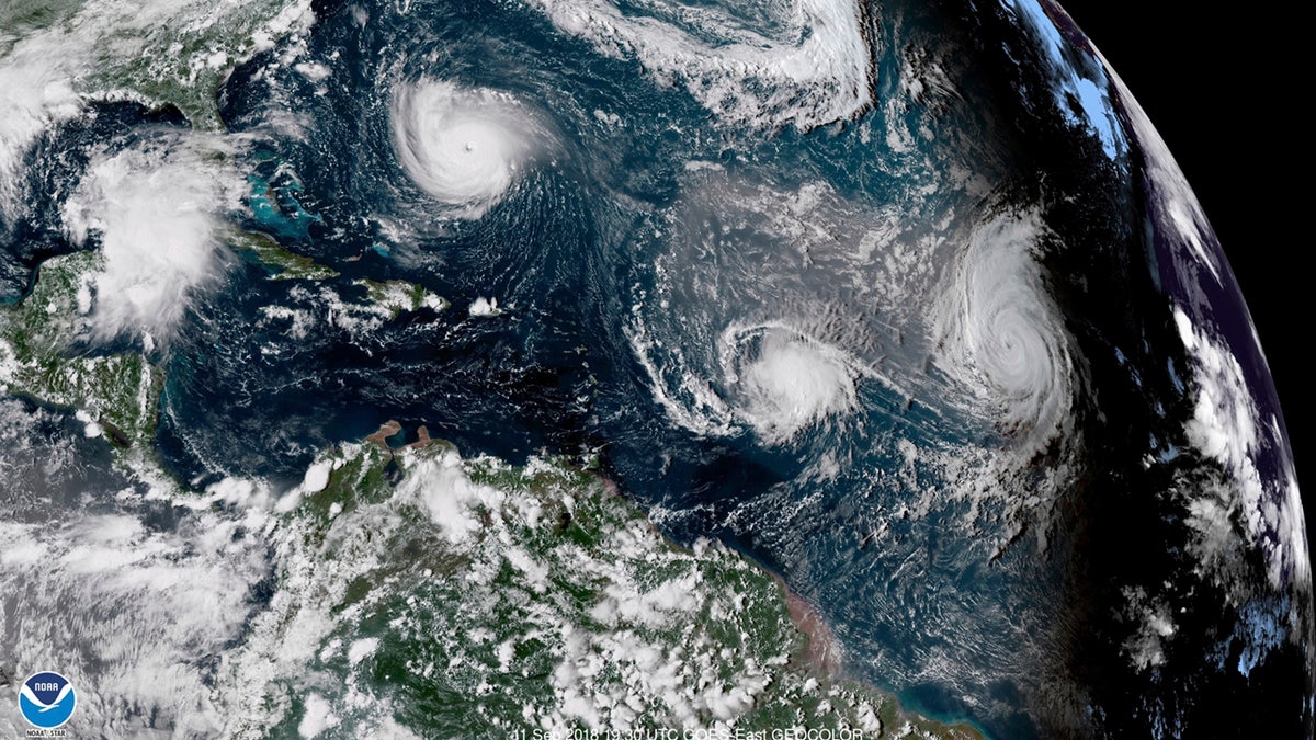 This enhanced satellite image made available by NOAA shows Tropical Storm Florence, upper left, in the Atlantic Ocean on Tuesday, Sept. 11, 2018 at 3:30 p.m. EDT. At center is Tropical Storm Isaac and at right is Hurricane Helene.