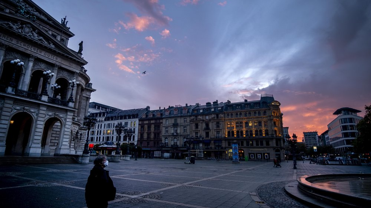 <br>
A woman wearing a face mask walks past the Old Opera, left, in Frankfurt, Germany, before sunrise on Monday, Nov. 9, 2020. (AP Photo/Michael Probst)