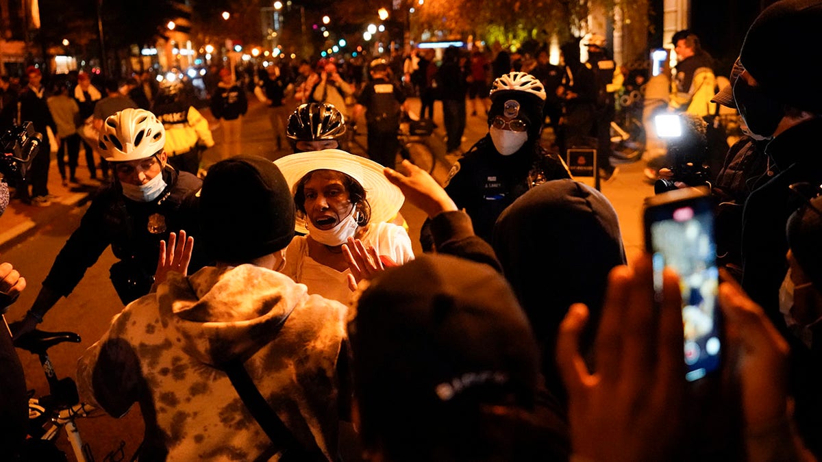 A supporter of President Trump, third from left in white hat, argues with counter-protestors after pro-Trump marches were held Saturday, Nov. 14, 2020, in Washington. (AP Photo/Julio Cortez)