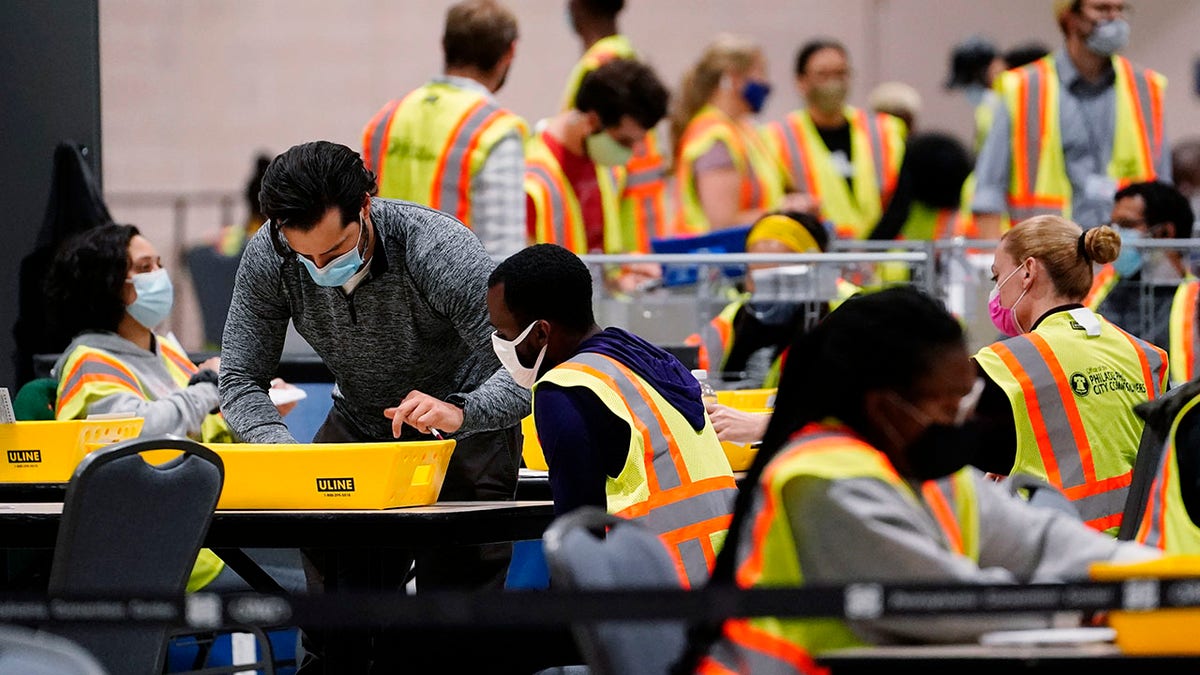 Philadelphia election workers process mail-in and absentee ballots for the general election, at the Pennsylvania Convention Center, Tuesday, Nov. 3, 2020, in Philadelphia. (AP Photo/Matt Slocum)