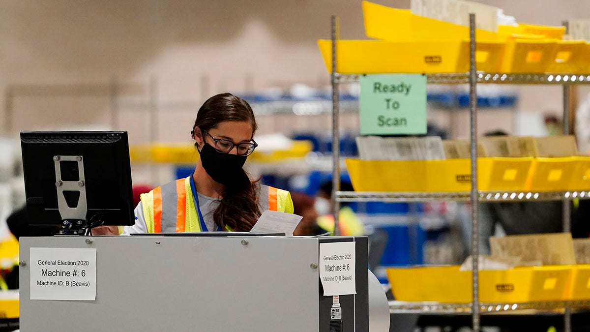 A Philadelphia election worker scans ballots for the 2020 general election in the United States at the Pennsylvania Convention Center, Tuesday, Nov. 3, 2020, in Philadelphia. (AP Photo/Matt Slocum)