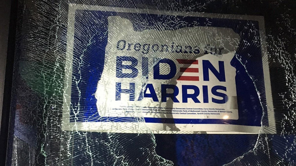A group vandalized the Multnomah County Democrats office in Portland on Sunday. An Oregonians for Biden-Harris campaign poster is seen behind the shattered glass window. (Portland Police Bureau)
