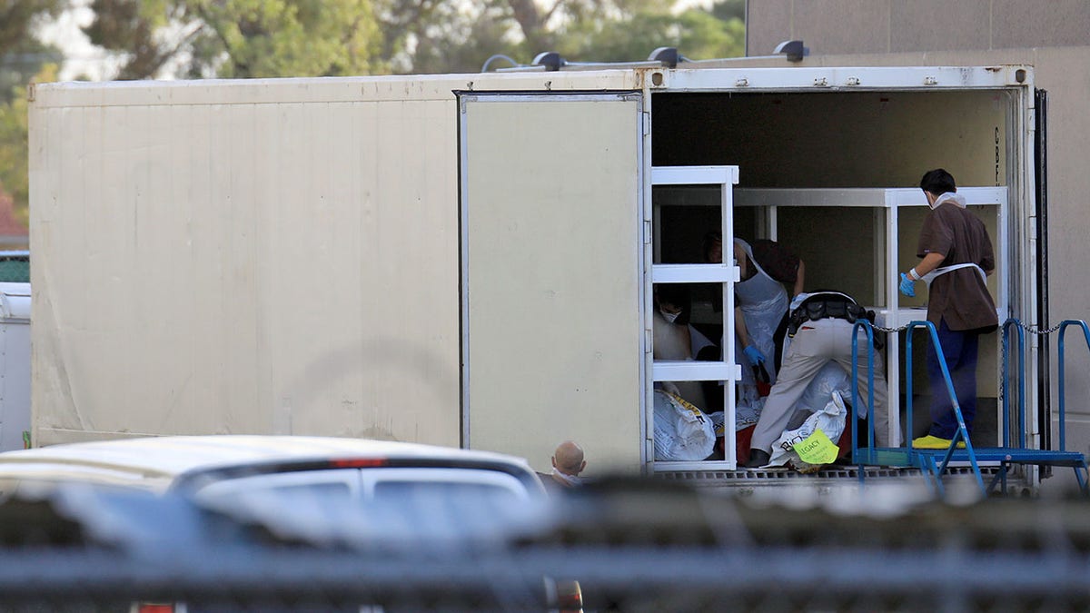 Medical workers are seen in one of three refrigerated trailers, sent by the Federal Emergency Management Administration (FEMA) to help with the rising number of coronavirus disease (COVID-19) fatalities, at the rear of the El Paso County Office of the Medical Examiner in El Paso, Texas, U.S. November 9, 2020. REUTERS/Jorge Salgado - RC200K9NNIYS