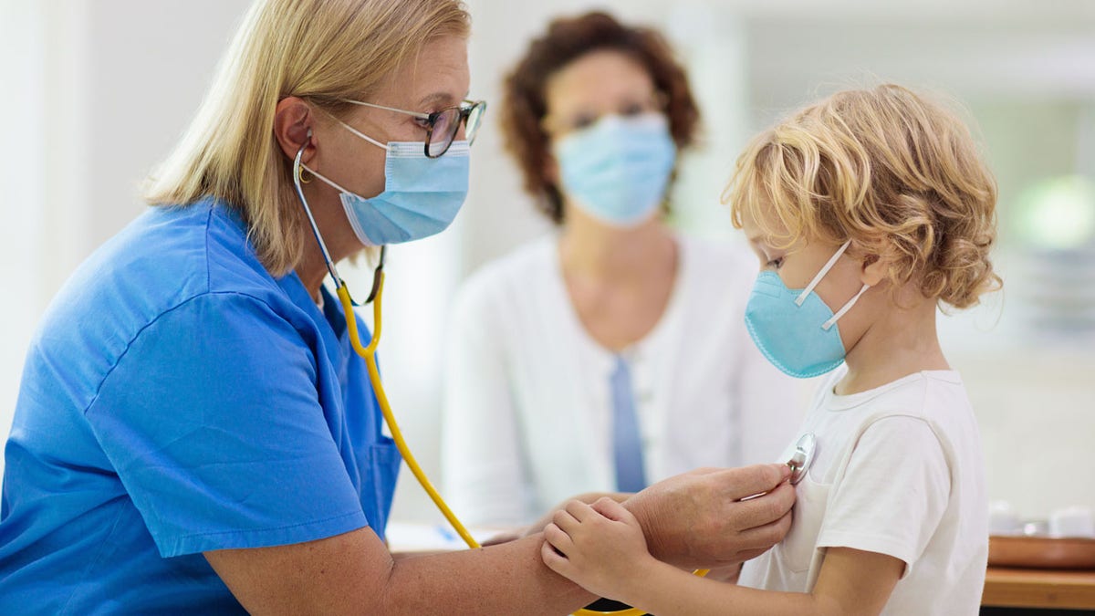 sick child is checked by doctor