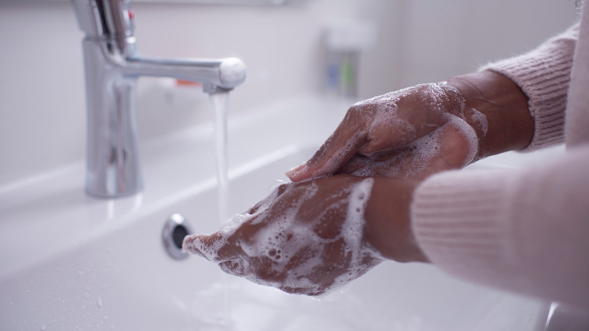 person washing his hands with soap and water