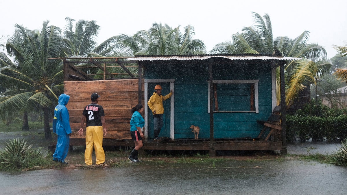 Residents stand outside a home surrounded by floodwaters brought on by Hurricane Eta in Wawa, Nicaragua, Tuesday, Nov. 3, 2020. AP Photo/Carlos Herrera